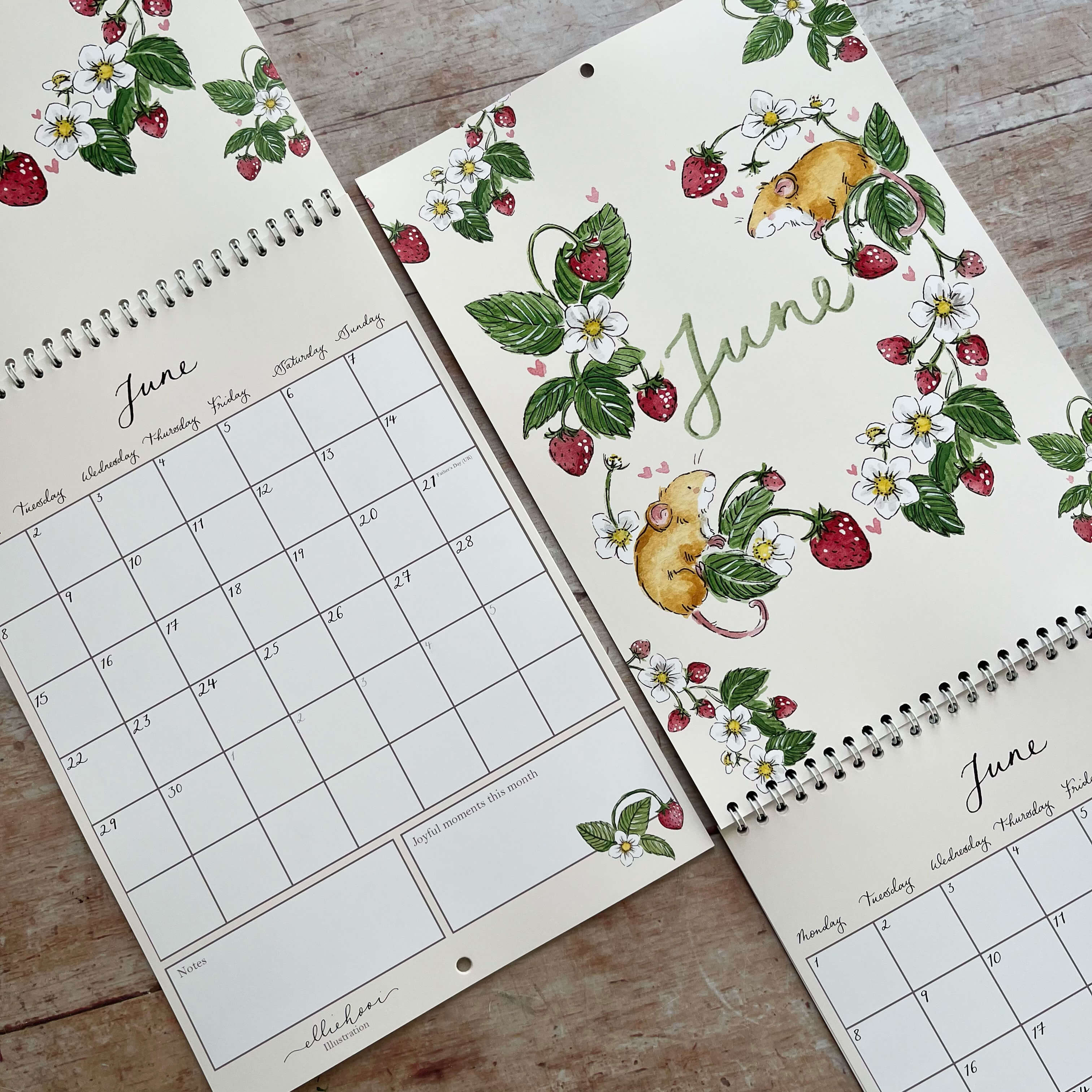 Three calendar pages for June with floral and mouse designs on a wooden surface.